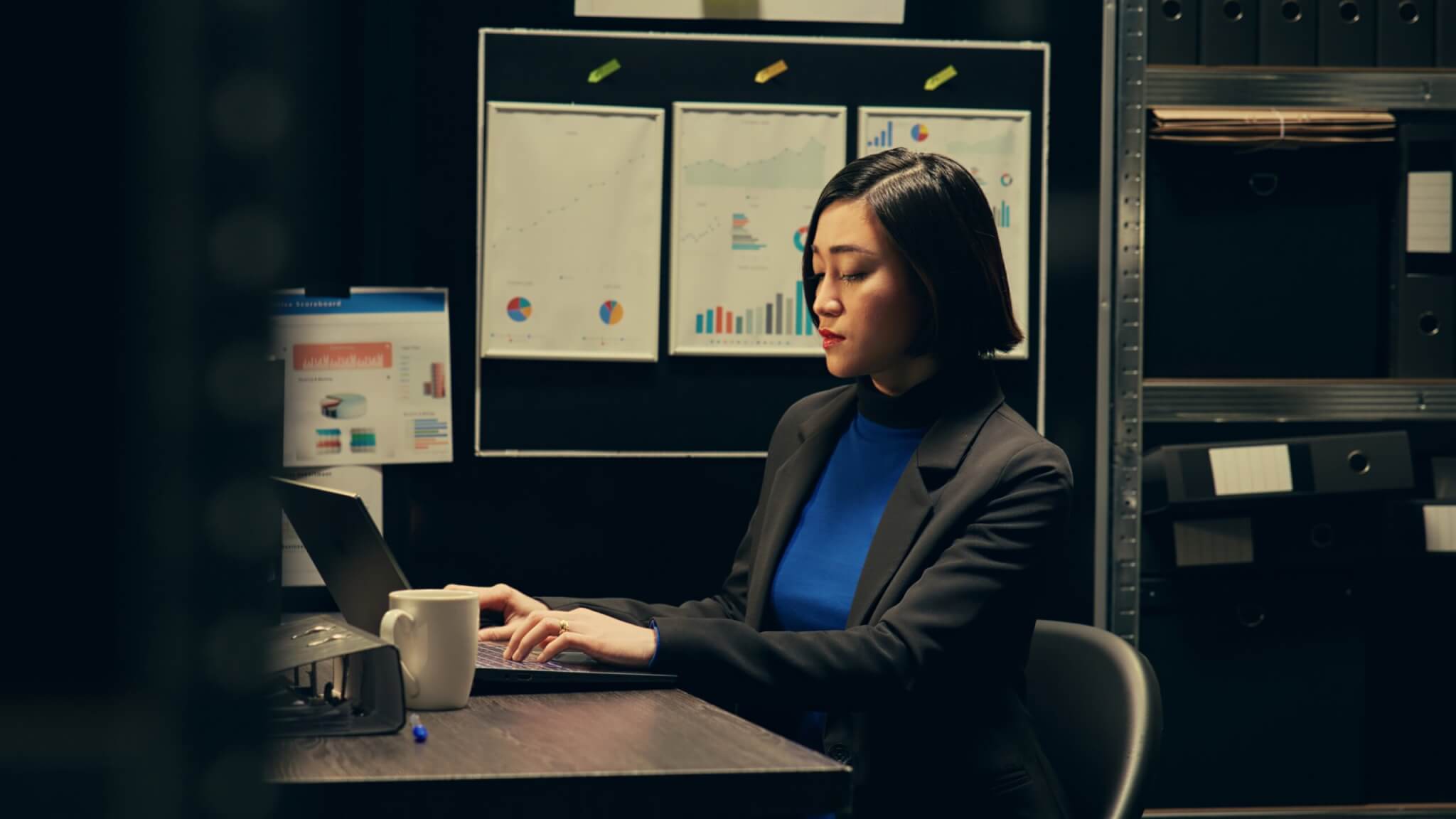 Law enforcement strategist reviewing training data and performance metrics at her desk